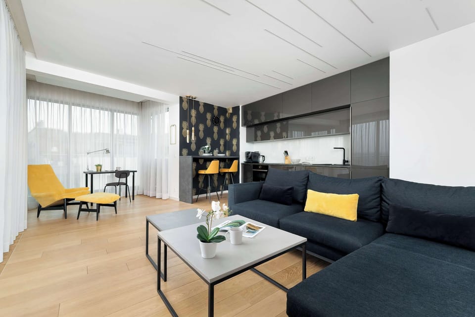 A stylish seating corner near large windows featuring a small table and chairs, ideal for casual dining or working.