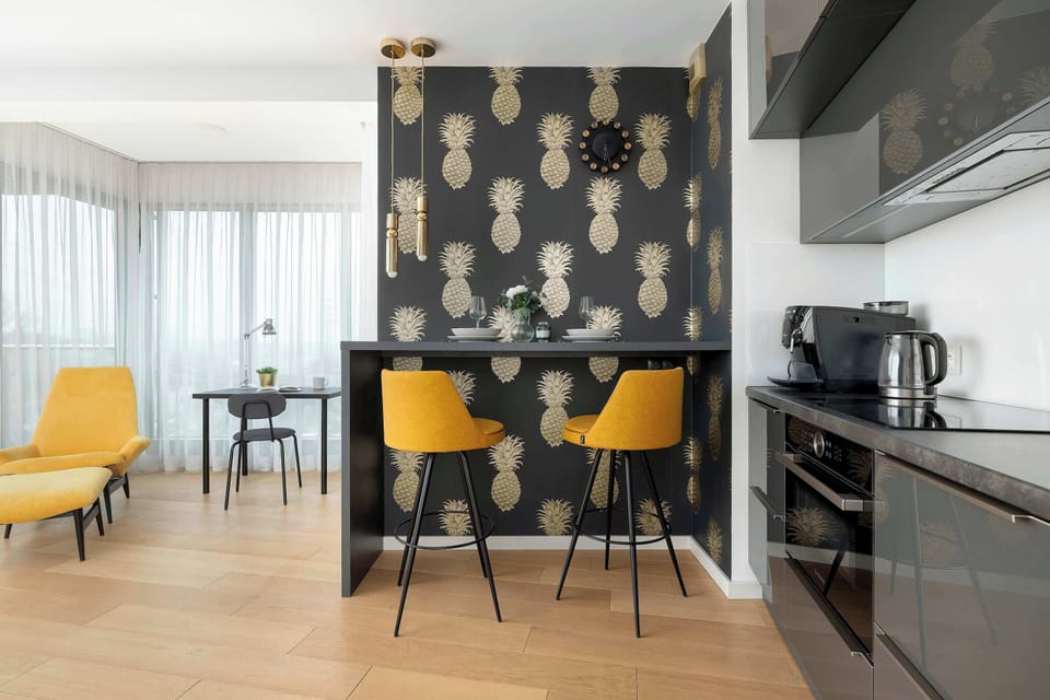 A modern dining area with high stools at the counter, designed in a consistent, elegant style.
