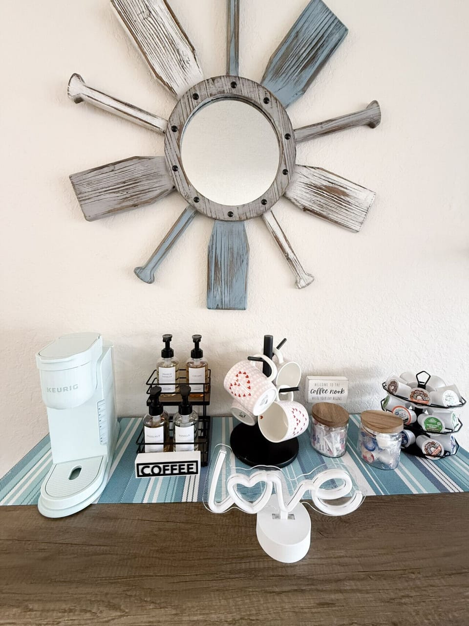 Charming coffee nook with a Keurig, flavored syrups, and coastal décor—perfect for your morning brew retreat.