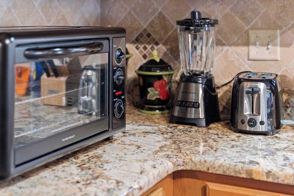 Kitchen countertop with toaster oven, blender, and toaster for convenient meal preparation.