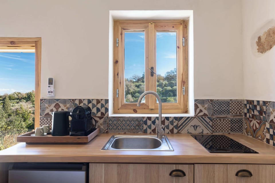 Fully Equipped Kitchenette with Stone Countertop and Window View