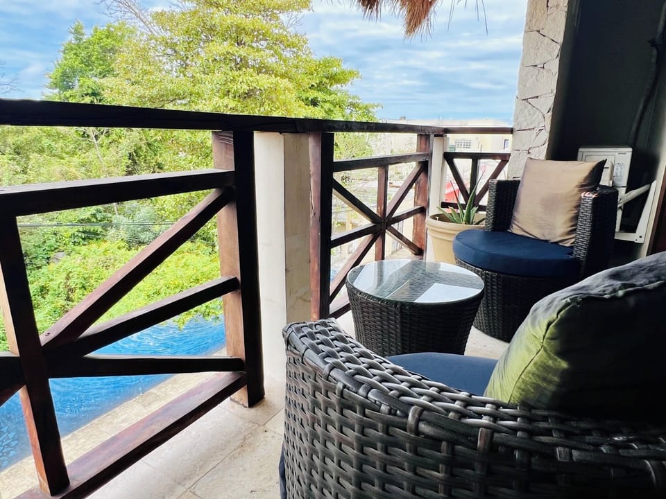 Private suite balcony with comfortable wicker seating and lush tropical views.