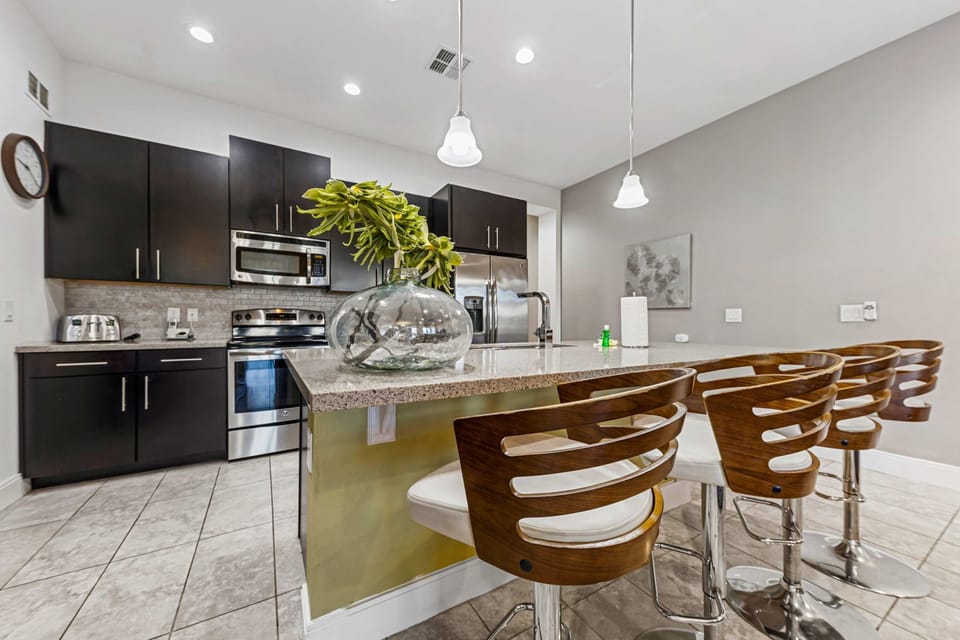 Modern kitchen with a large island and stylish wooden bar stools for casual dining.