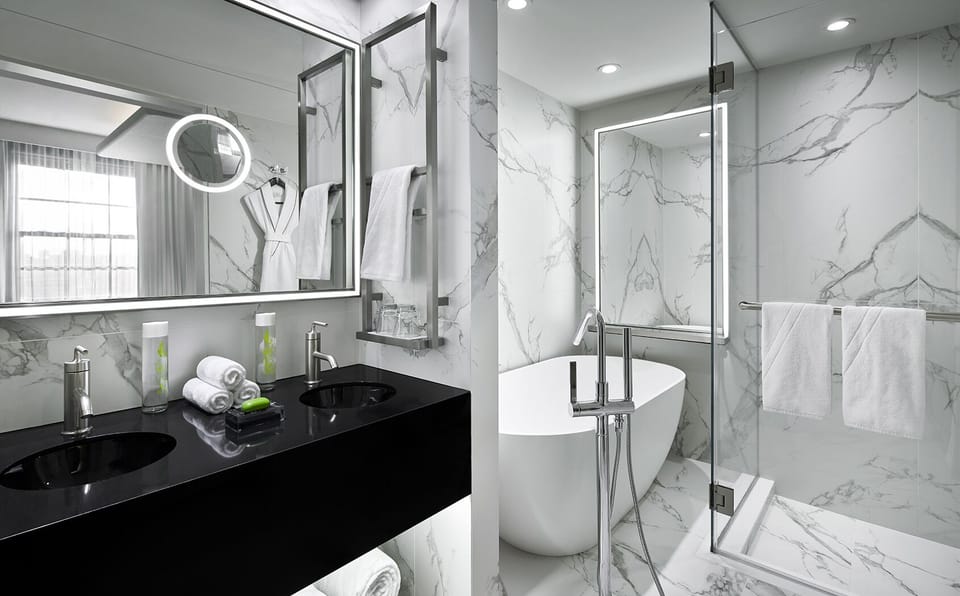 Unwind in a marble spa bath with glowing vanity lights.