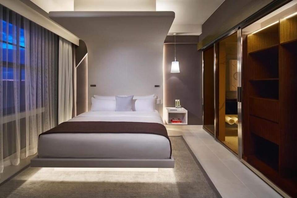 Unwind in a sleek king bed with soft, ambient lighting.