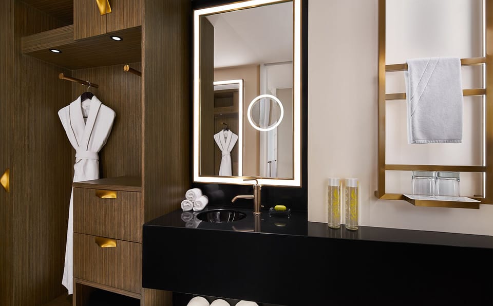 Refresh at the sleek vanity with fluffy towels and soft lighting.