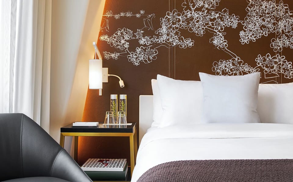 Relax into quiet comfort with bedside lighting and plush linens.