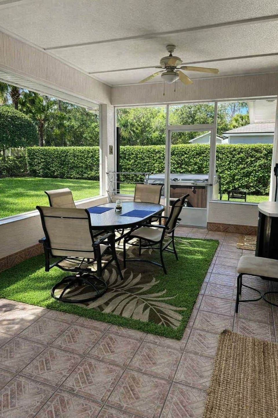 Screened lanai with a cozy table overlooking the private, tropical fenced backyard