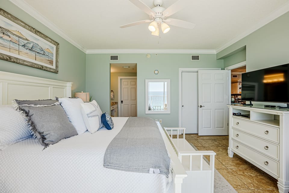 Master bedroom with king bed, ceiling fan, smart TV, clothing storage and ensuite bathroom