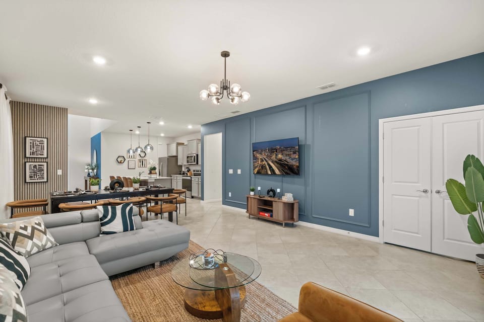 Elegant living area with a modern sectional and dining space, perfect for entertaining and relaxation.