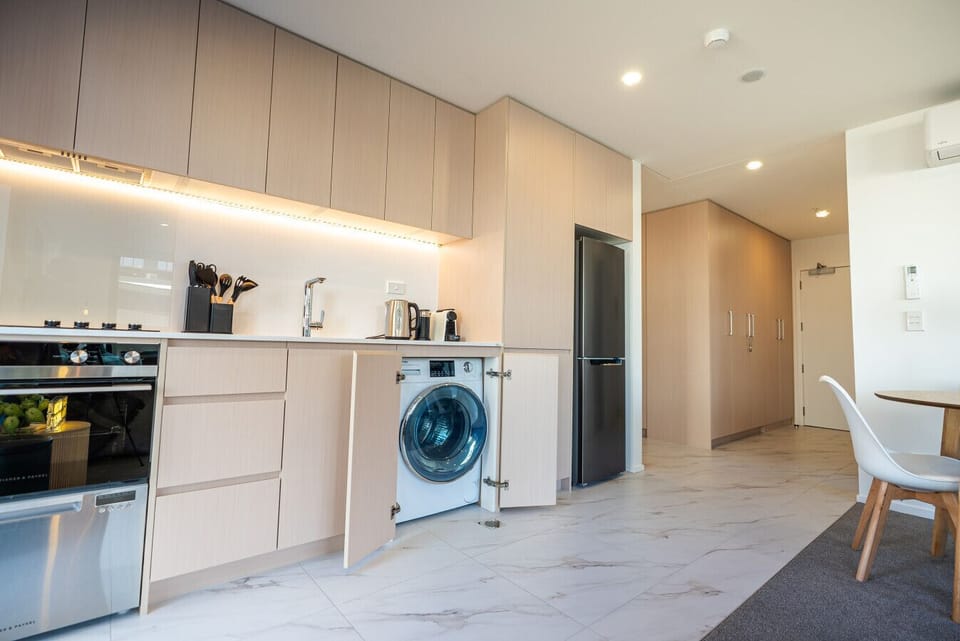 modern kitchen with sleek cabinetry, quality appliances, and in-unit washer for ultimate convenience.”