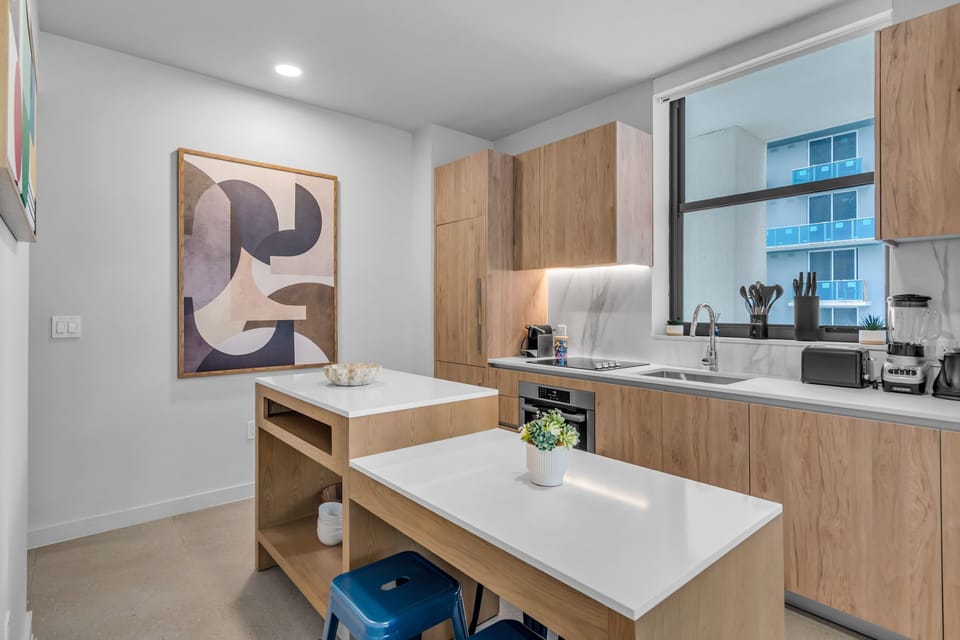 his sleek kitchen features custom cabinetry and a social island with seating for 4. Perfect for whipping up a feast or a late-night snack in the heart of Miami Worldcenter. Dinner is served!