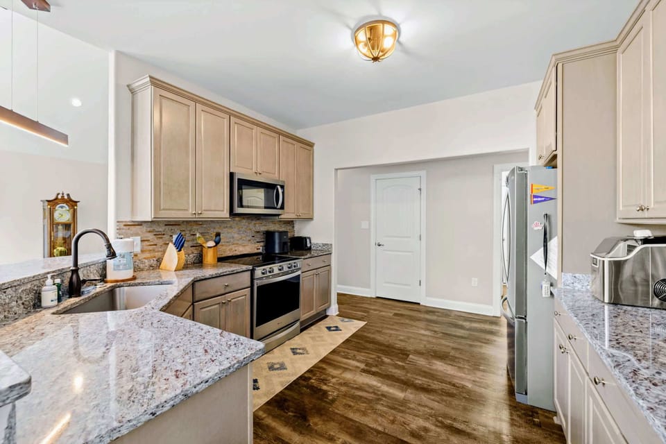 Kitchen - Cream cabinetry, granite counters, and stainless appliances keep the chef well equipped.