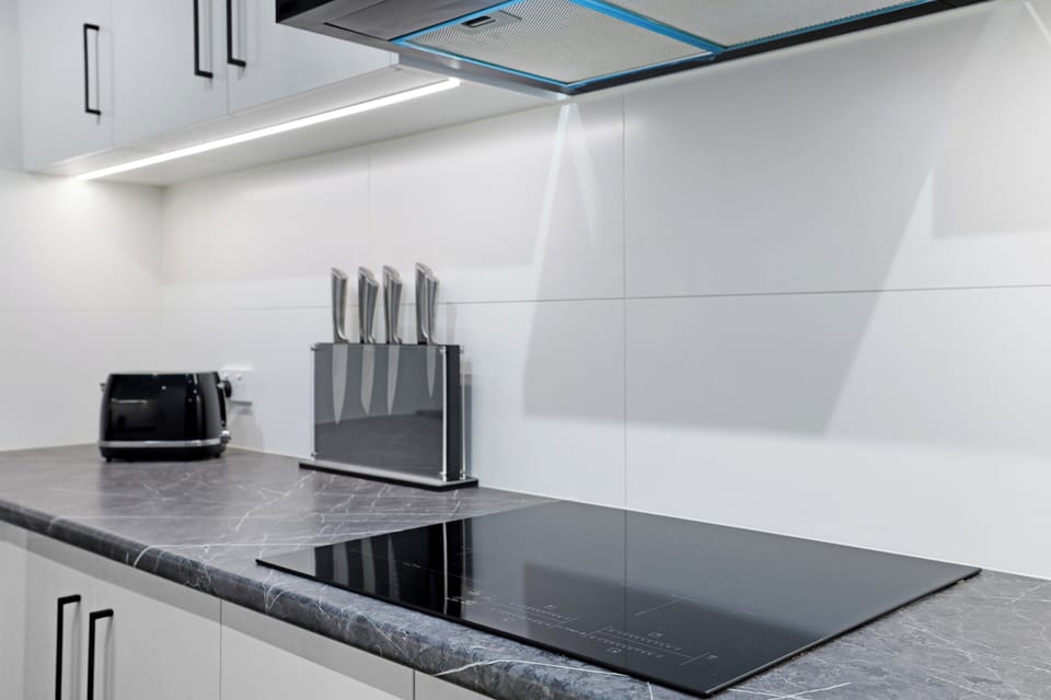Cooking zone with practical bench space and overhead task lighting.