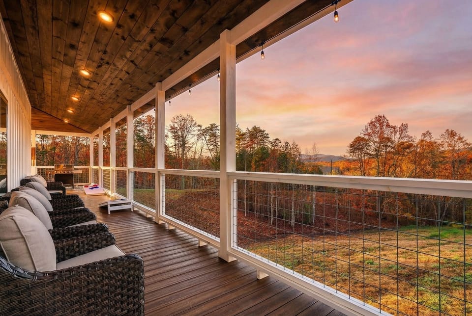 Unwind on the covered balcony with sunset skies, treetop scenery, and a game of cornhole.