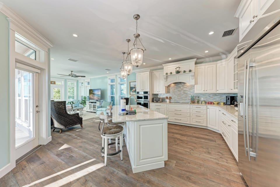 Gather around the spacious island in your gourmet kitchen, where elegant pendant lights illuminate culinary adventures and morning coffee feels special.