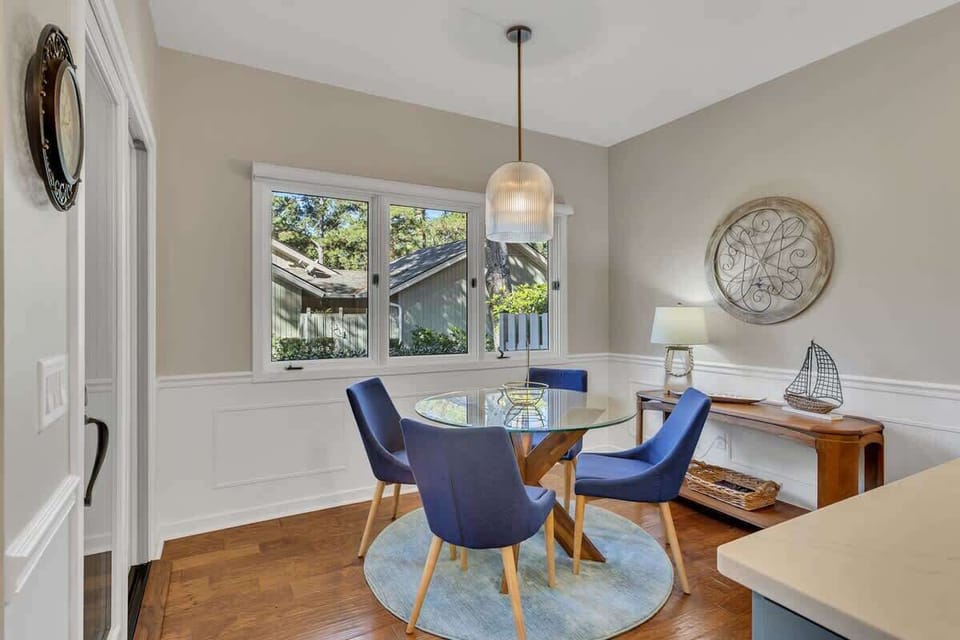 Gather around your elegant glass dining table where natural light streams through large windows, creating the perfect spot for memorable meals.