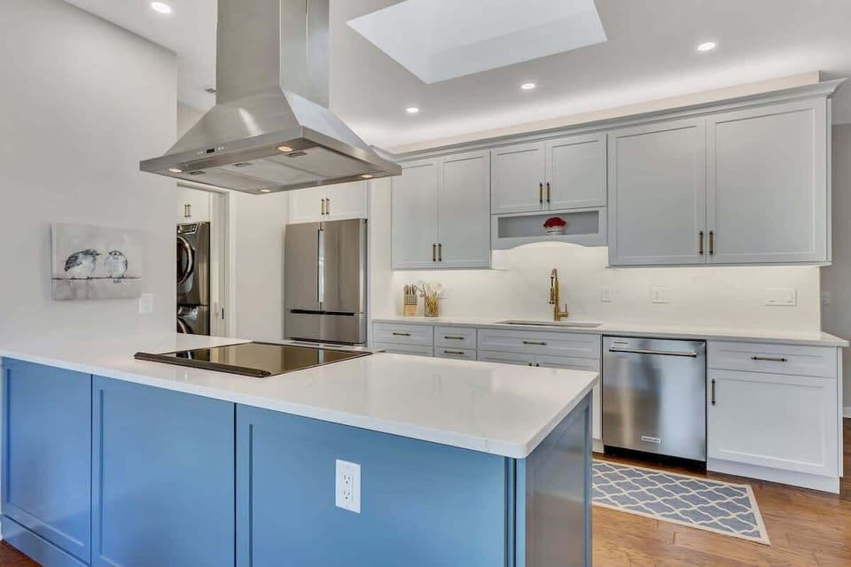 Your gourmet kitchen awaits with gleaming stainless appliances, spacious island, and elegant blue accent cabinetry for memorable culinary moments.