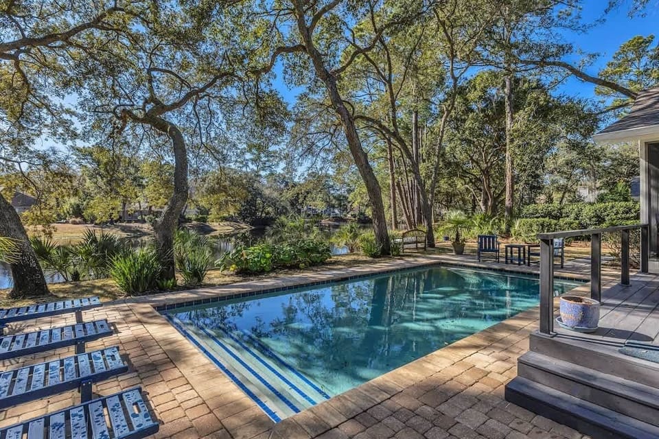 Sparkling pool nestled among towering oaks creates your private outdoor sanctuary for relaxation and recreation.