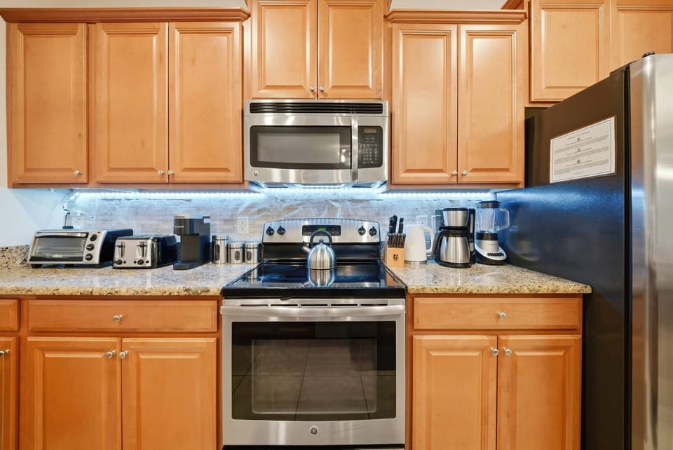Welcome to a cozy kitchen featuring warm wooden cabinetry and sleek granite countertops, perfect for your cooking adventures. Stainless steel appliances shine under soft lighting, creating a welcoming atmosphere for meal prep.