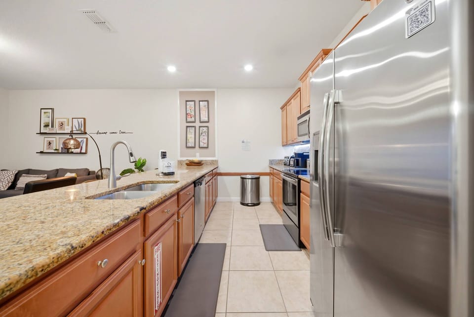 This inviting kitchen boasts lovely wooden cabinets and elegant granite countertops, creating a warm and functional space ideal for culinary adventures and entertaining, complete with stainless steel appliances and plenty of.