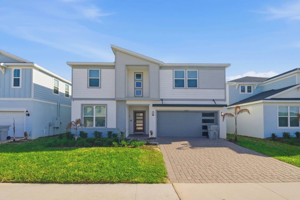 Discover a bright, stylish home with a sleek façade and large windows. The well-defined landscaping and paved driveway welcome you to a space where comfort blends seamlessly with contemporary design.