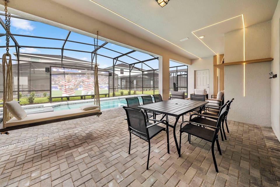 Welcome to a bright, airy space filled with natural light and featuring a stylish outdoor dining set. The warm brick flooring complements the inviting swing, perfect for relaxing and unwinding by the pool.