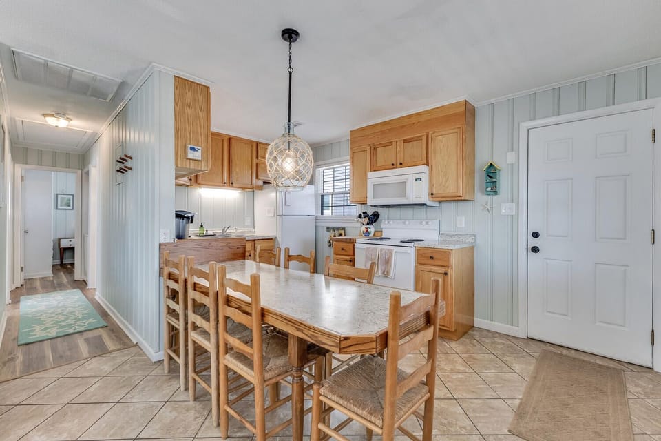 Your fully equipped kitchen awaits with warm wood cabinets, granite counters, and a cozy dining table for memorable meals together.