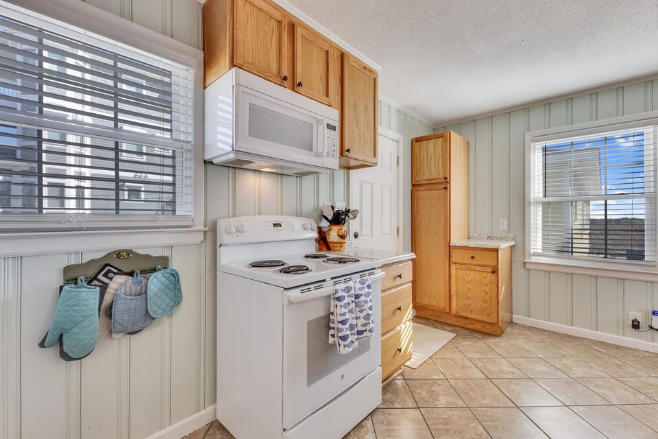 Your fully equipped kitchen awaits with everything needed to prepare meals, featuring warm wood cabinets and plenty of counter space.