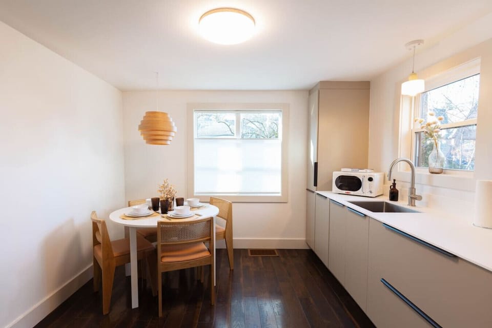 Contemporary kitchen with induction cooking, stainless steel appliances, microwave, and a chic SMEG drip coffee maker.