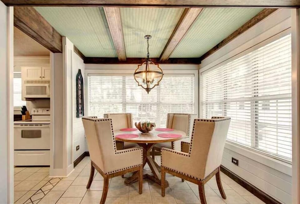 Dining area with wooden table and four chairs.