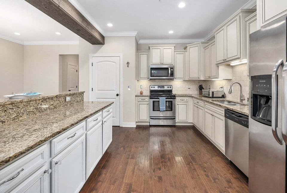 White kitchen with granite counters and stainless appliances