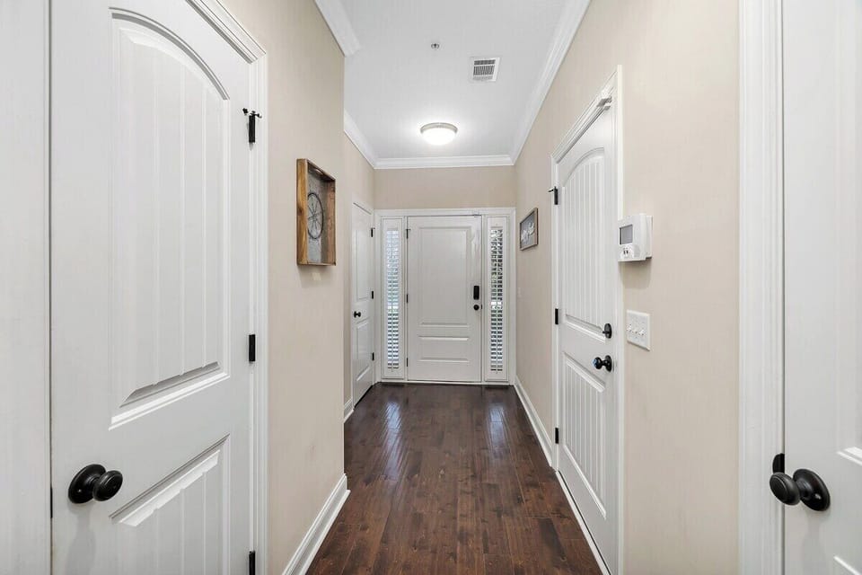Hallway with white paneled doors and wood floors
