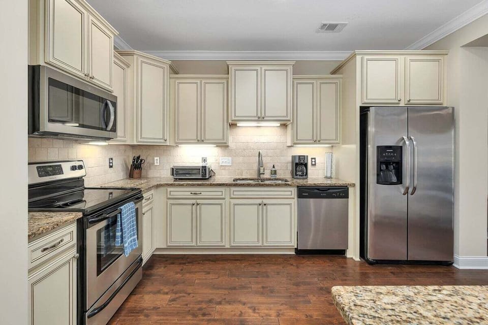 Cream kitchen with stainless appliances and granite counters