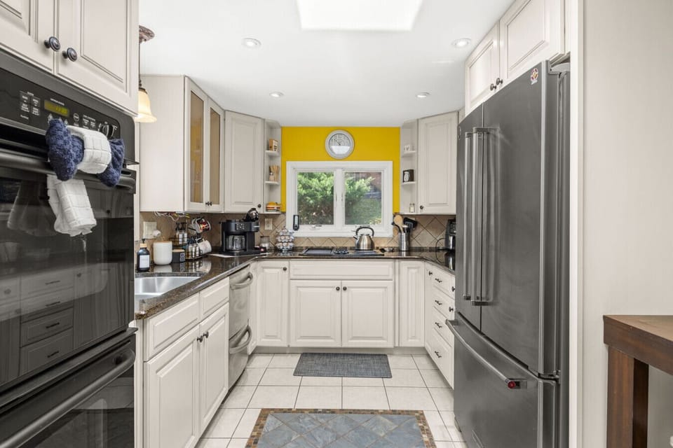 Fully equipped modern kitchen with stainless steel appliances, bright cabinetry, and sleek countertops—perfect for cooking and entertaining during your lakefront stay.