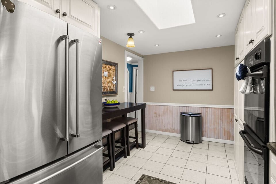 Spacious modern kitchen with stainless steel appliances, breakfast bar seating, and ample prep space—perfect for cooking and gathering during your lakefront stay.