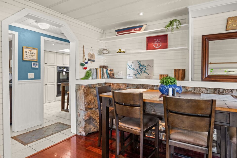 Charming lakefront dining nook with custom built-ins, rustic stone accents, and coastal décor—perfect for cozy meals and gatherings.