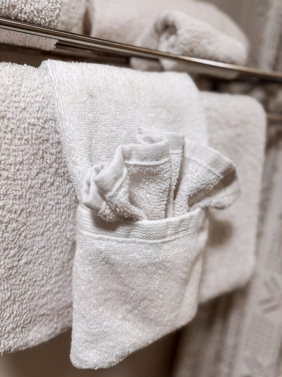 Luxurious white towels and bathrobes in a cozy hotel or spa setting, offering premium comfort and relaxation.