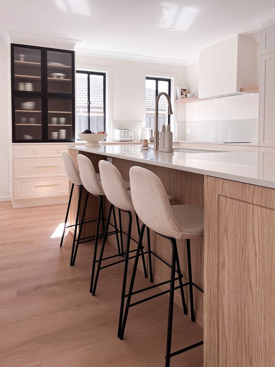 Kitchen : Bar stools at the kitchen island add casual seating beside the bench, sink and main kitchen workspace.