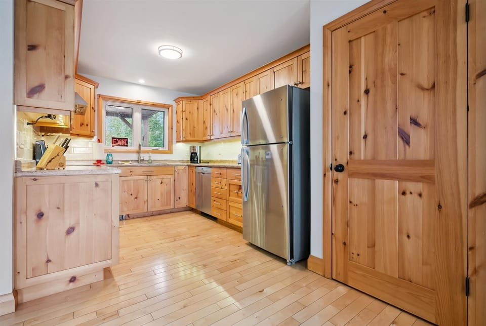 Enjoy a fully equipped kitchen with warm wood cabinetry and modern stainless steel appliances for easy cottage meals.