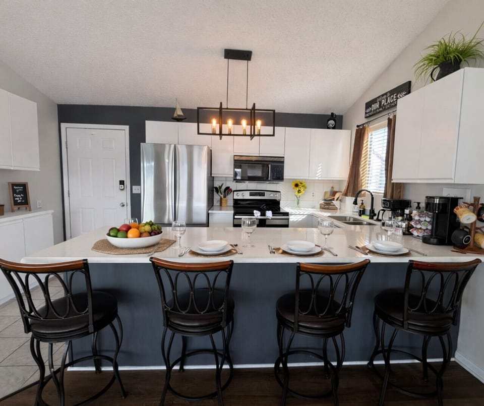 Modern lake house kitchen with stainless steel appliances, sleek island seating, and stylish contemporary design.