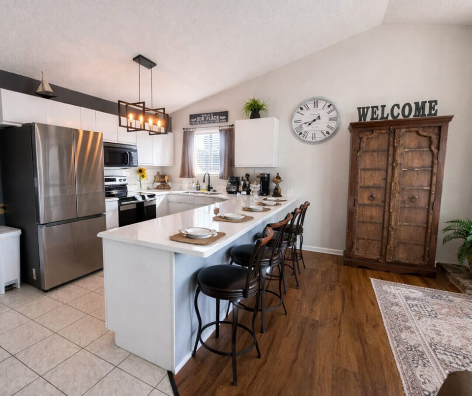 Inviting lake house kitchen with stainless steel appliances, large breakfast bar, and charming rustic-modern decor.