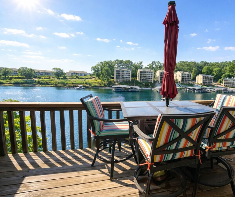 Private lakefront deck with outdoor dining seating and panoramic water views—perfect for sunrise coffee, sunset drinks, and relaxing waterfront getaways.
