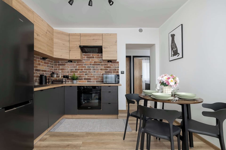 A sleek kitchen corner showcases grey cabinetry, wooden countertops, and a modern black oven.