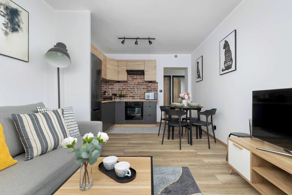 The open-concept living area combines a cozy lounge with a modern dining table and a glimpse of the kitchen.
