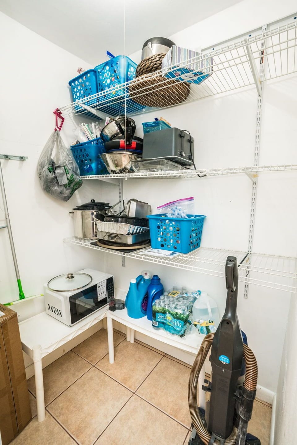 Your storage pantry keeps everything organized with shelving, a microwave for quick meals, and cleaning supplies for your convenience.