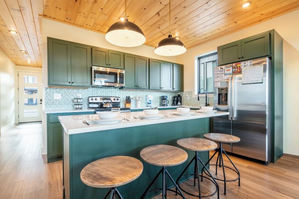 Step into your fully equipped kitchen with modern appliances, stylish cabinetry, and a breakfast bar perfect for morning coffee or meal prep during your stay.