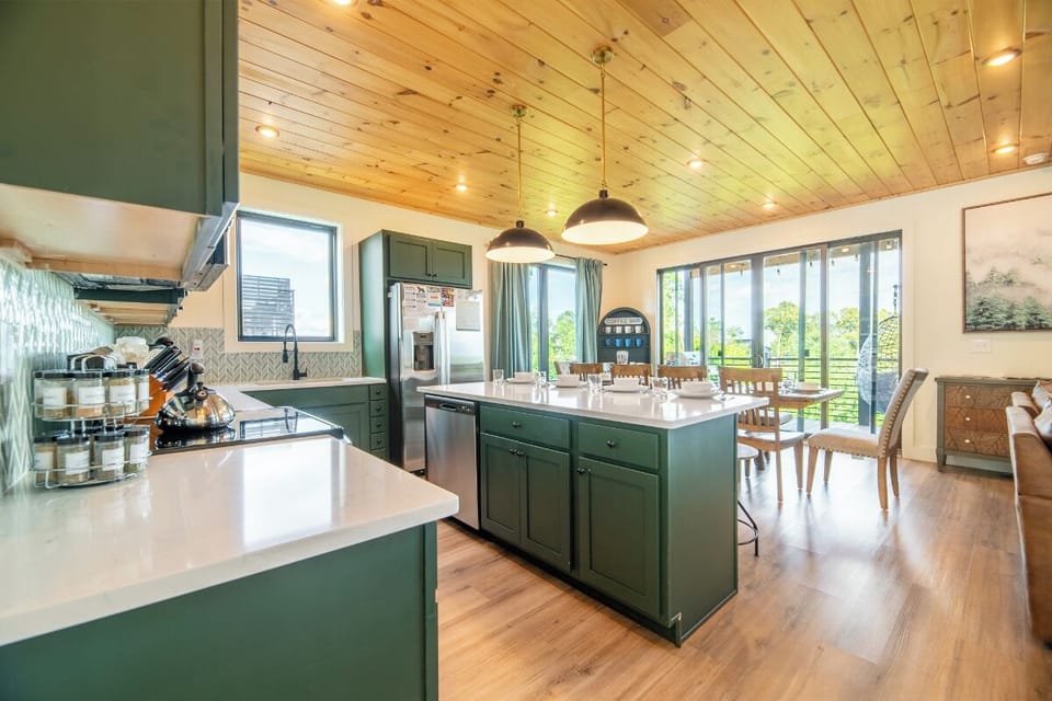 Gather around the spacious kitchen island where you can prep meals together while natural light pours in through the glass doors, creating a warm and inviting atmosphere for shared moments.