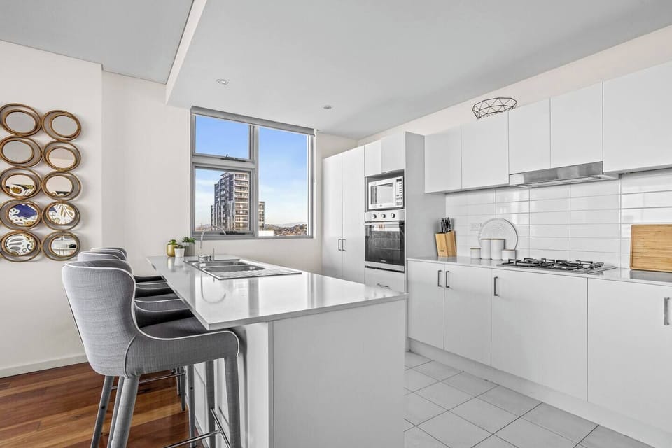 Cook with ease in the generous modern kitchen featuring stone benchtops, quality appliances, and a large island with bar seating.