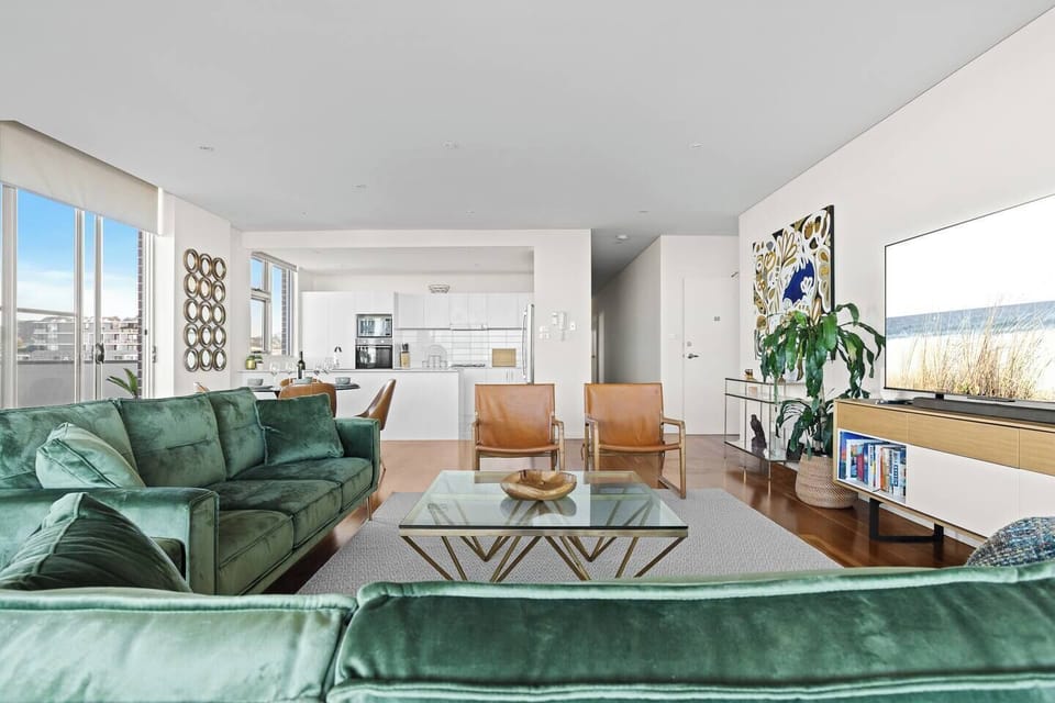 Relax in the spacious open-plan living area with comfortable seating for everyone, air conditioning, and seamless access to the balcony.